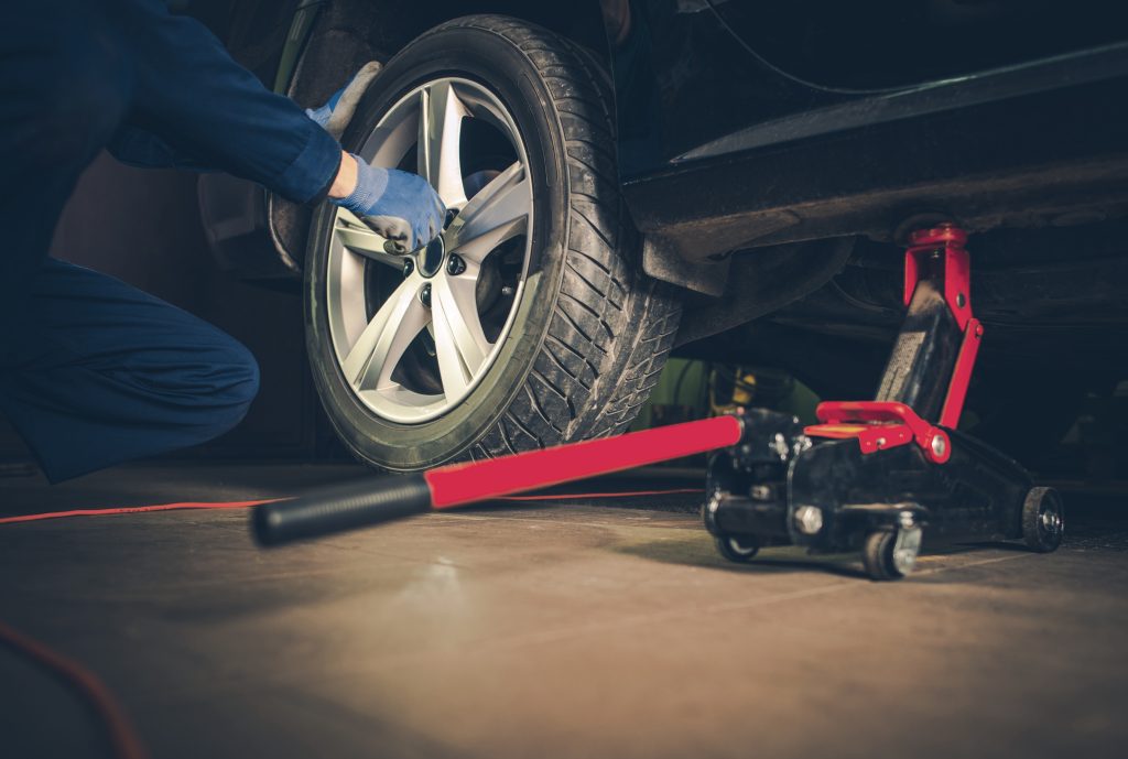 close up shot of a technician doing a tire rotation on a new Mitsubishi vehicle.