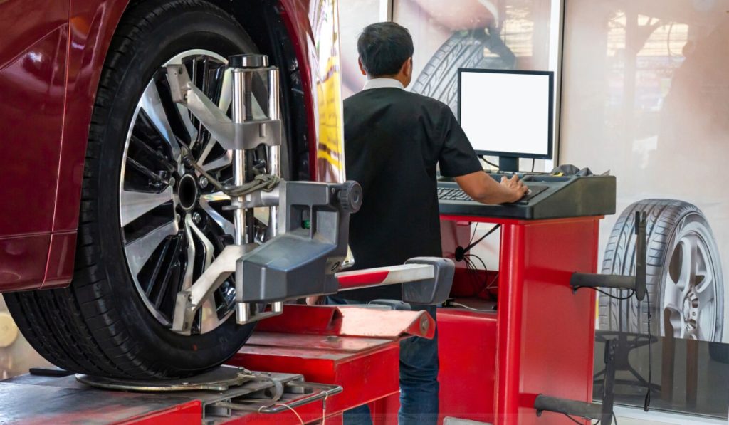 Mitsubishi tech performing a tire alignment.