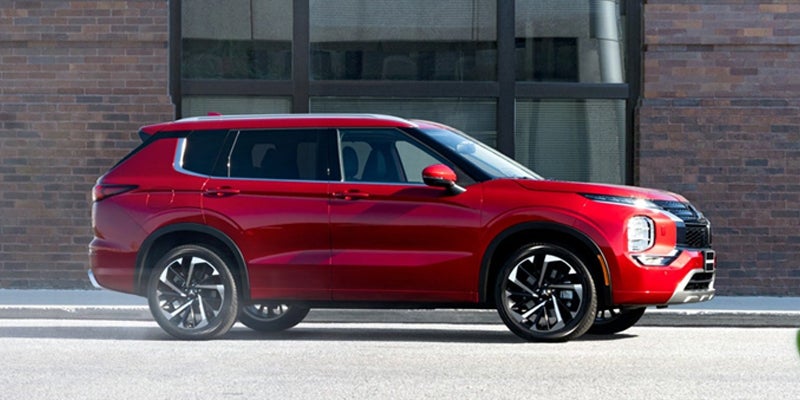 brand new 2024 Mitsubishi Outlander parked in front of a business building